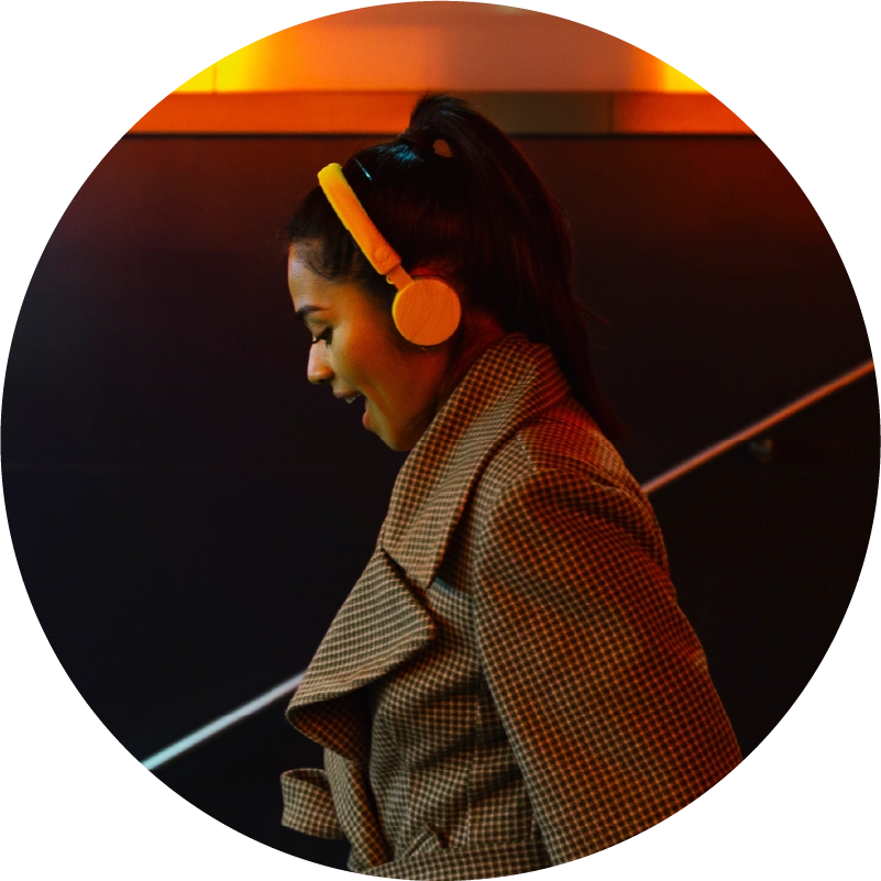 Woman with headphones on in orange backdrop