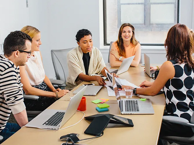 Team collaborating around a table teaser