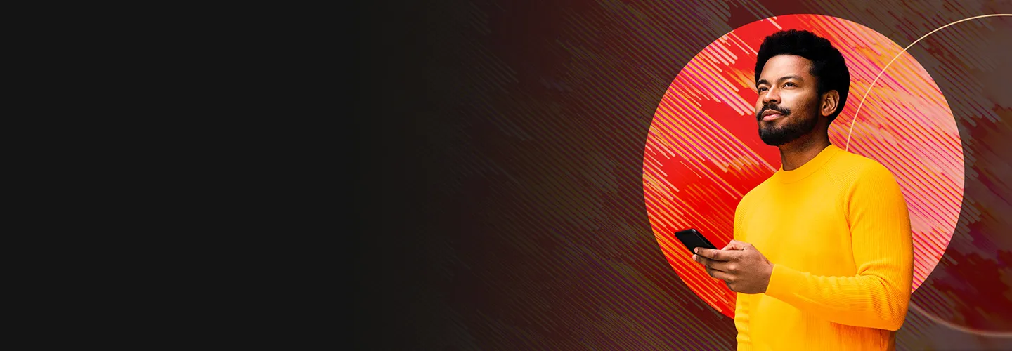 Man in front of orange backdrop smiling