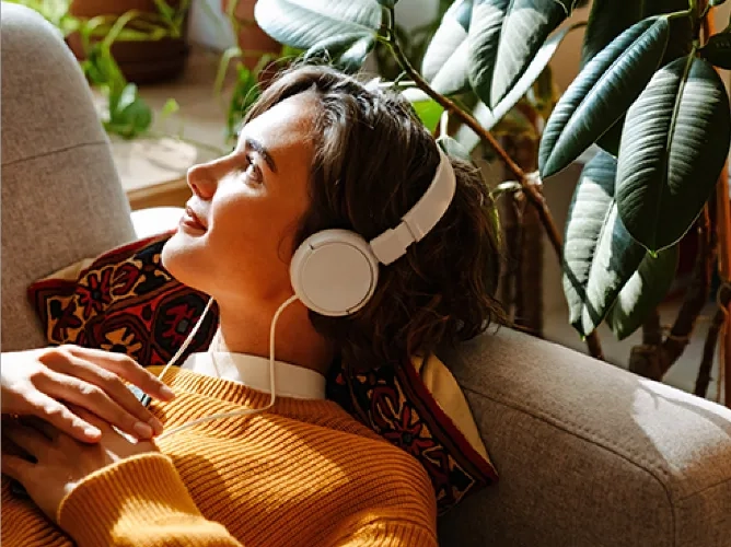 Woman with headphones on looking out window