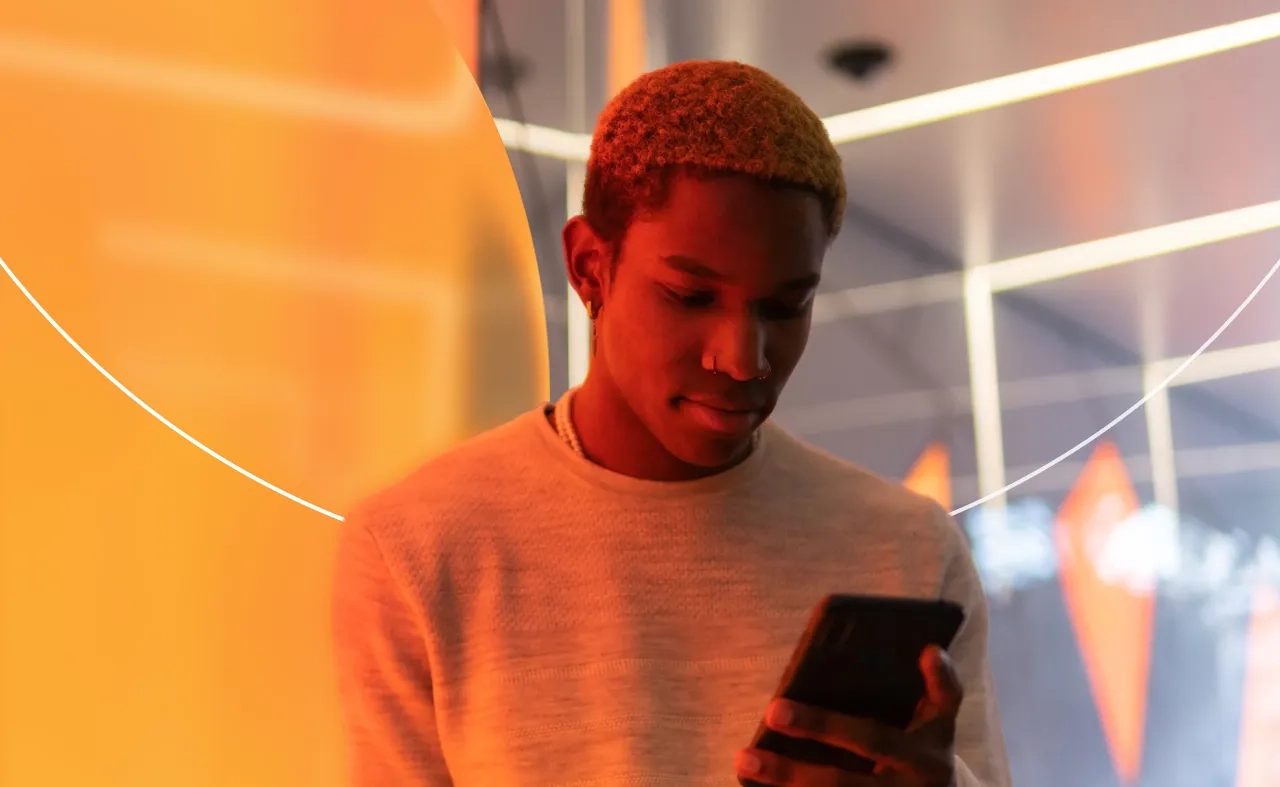 Man on phone in front of orange lighting